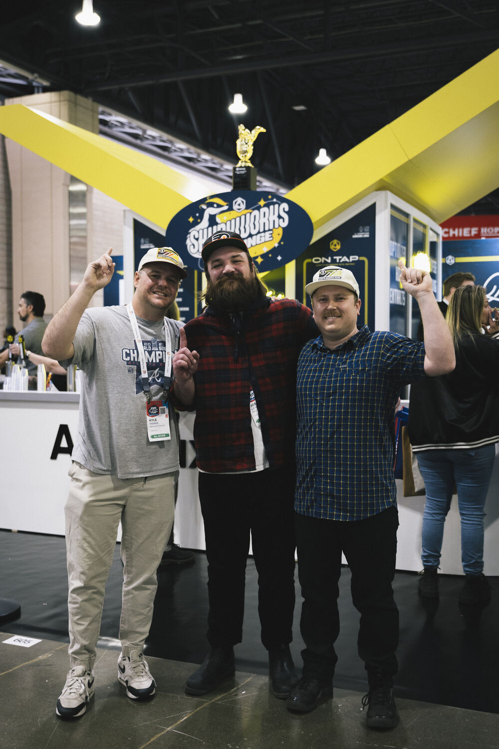 Reformation Brewery team celebrating at the 2026 Skunkworks Lounge booth beneath the trophy